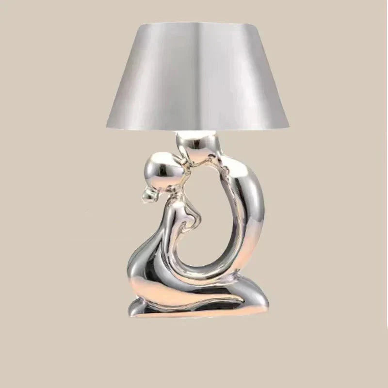 Lampada da tavolo scultorea con base a figura astratta metallica e paralume a tamburo affusolato