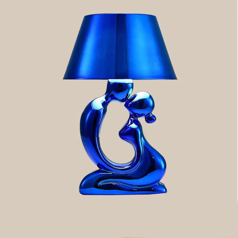 Lampada da tavolo scultorea con base a figura astratta metallica e paralume a tamburo affusolato